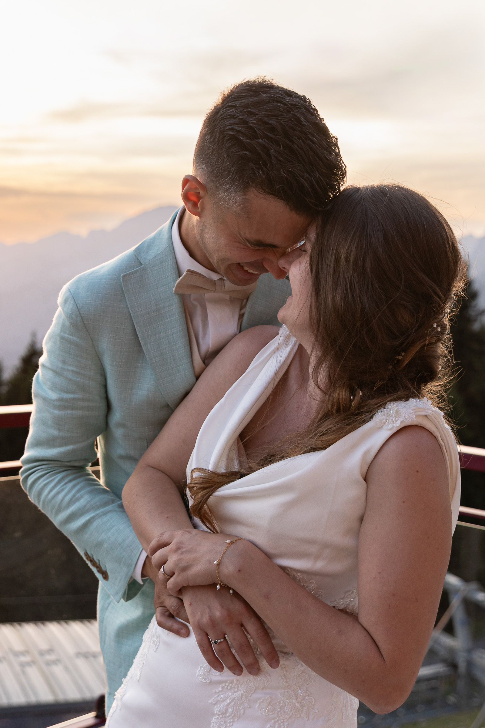 Mariés partageant un moment complice pendant le vin d’honneur sur la terrasse de l’Escale à Super-Châtel au coucher du soleil